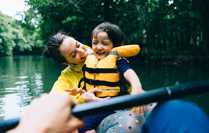 Eine Mutter sitzt mit ihrem Kleinkind in einem Gummiboot